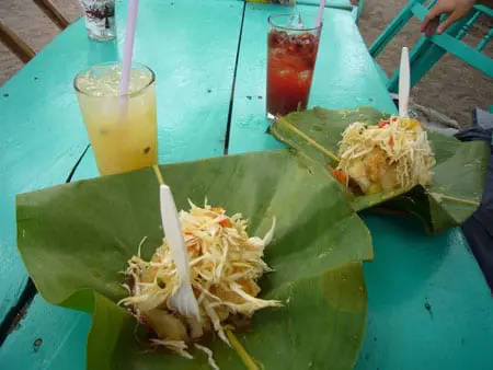Yuca Vigorón served in a banana leaf, cabbage and pork rind