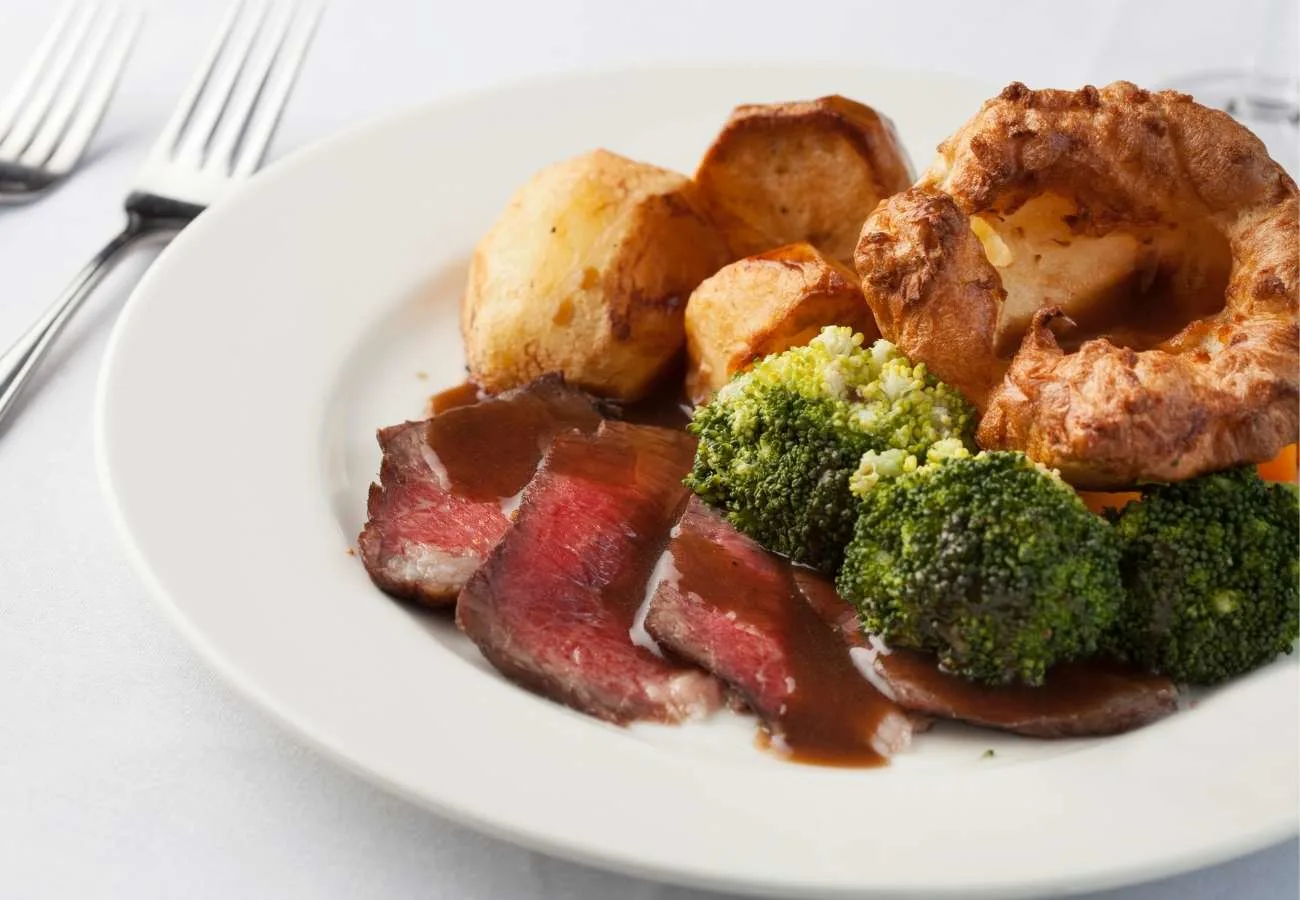 Sunday roast dinner with beef, yorkshire pudding and brocolli