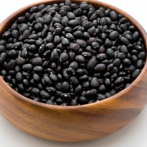 Black beans in a brown wooden bowl