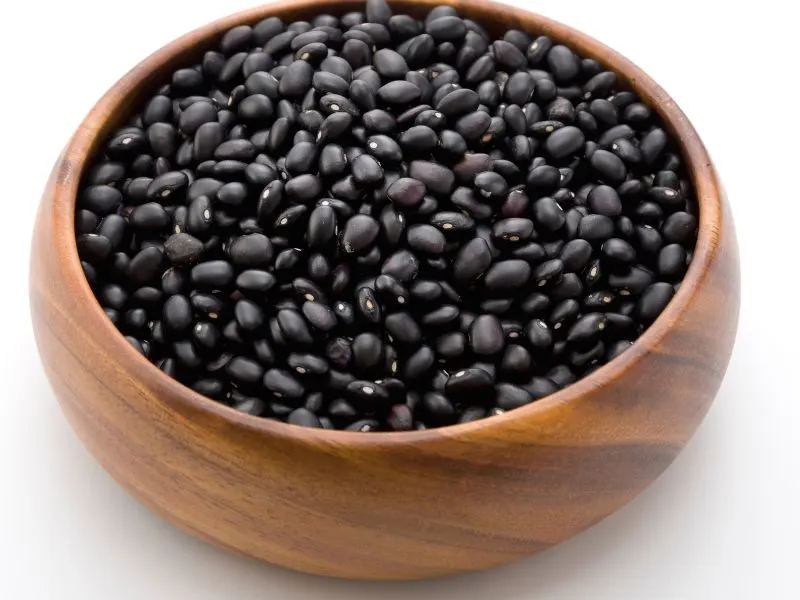Black beans in a brown wooden bowl