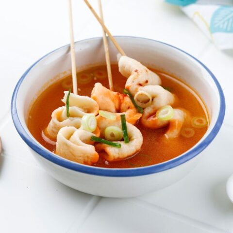 Odeng fish cakes on skewers in a broth