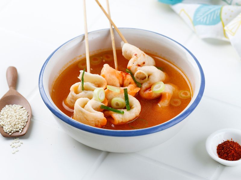 Odeng fish cakes on skewers in a broth