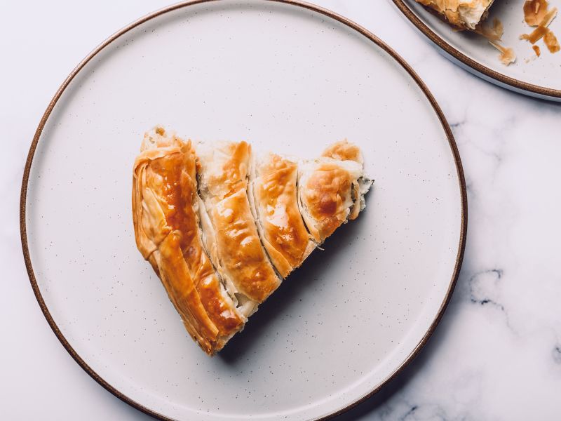 Savory meat pie in filo pastry on a white plate.