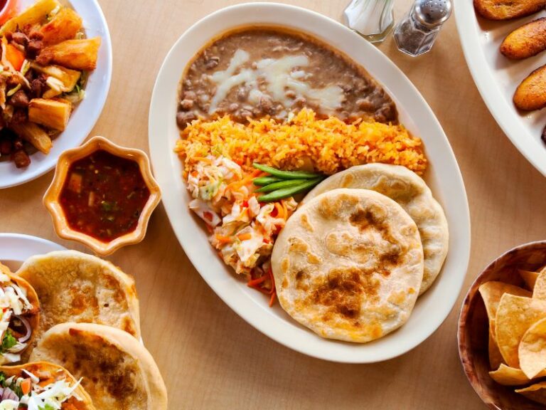 Plate of riguas with rice and refried beans on the side.