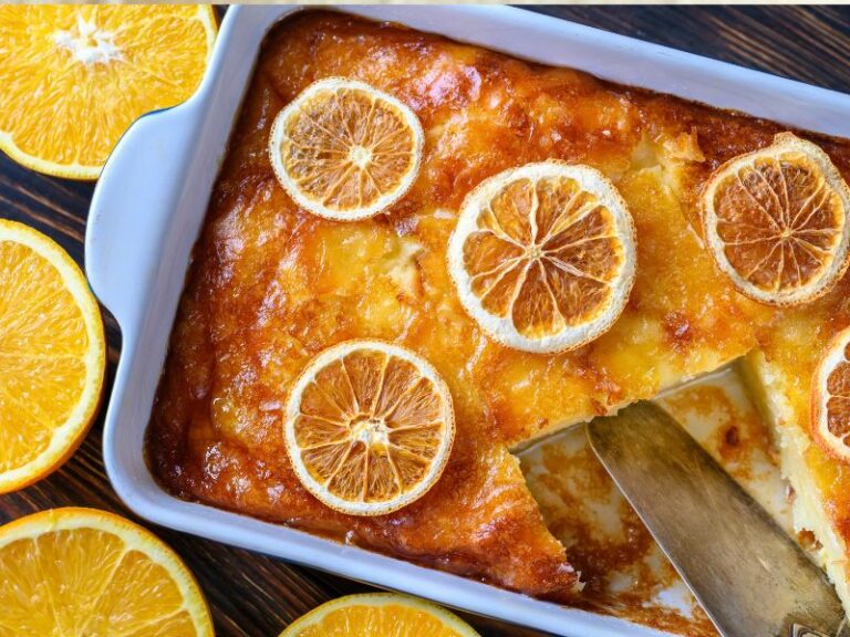 Portokalopita cake in a tin with oranges on top