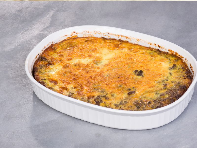 Food with crispy cheese on top in a white dish