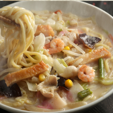 Bowl of noodles and seafood in a creamy broth