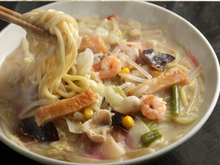 Bowl of noodles and seafood in a creamy broth