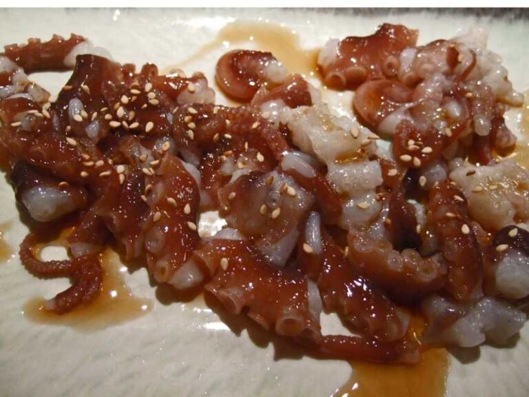 Sannakji in sesame oil and sprinkled with sesame seed.