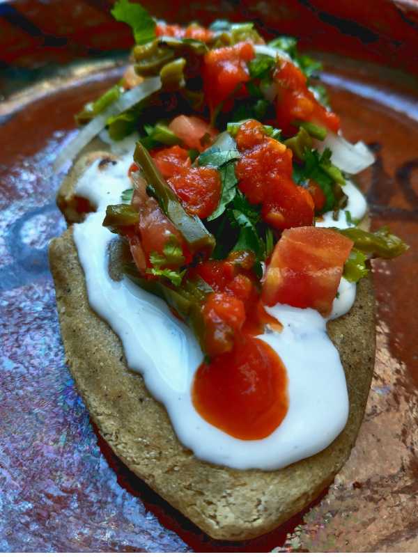 Tlacoyo with creamy white cheese topping.